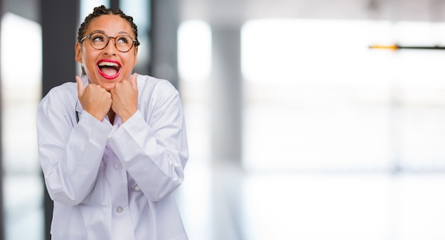 Retrato de una joven doctora negra muy feliz y emocionada.