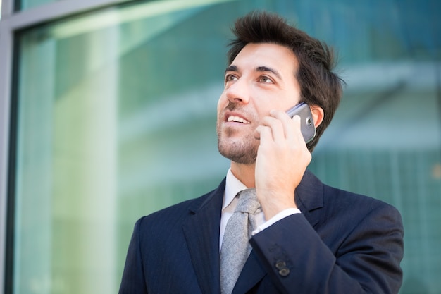 Retrato de un joven ejecutivo hablando por el teléfono celular