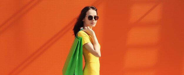 Retrato de una joven elegante y hermosa posando con bolsas de compras