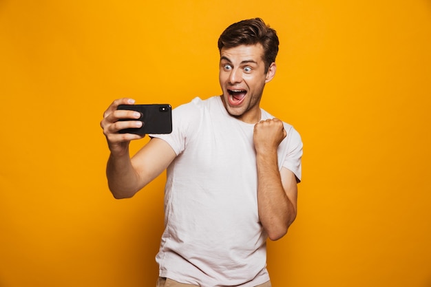 Retrato de un joven emocionado tomando un selfie