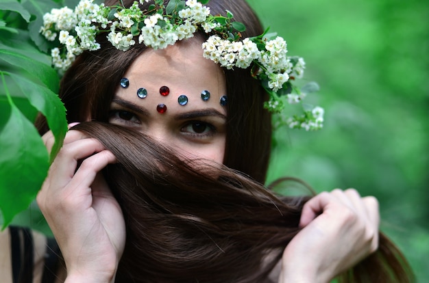 Retrato de una joven emocional con una corona floral en la cabeza