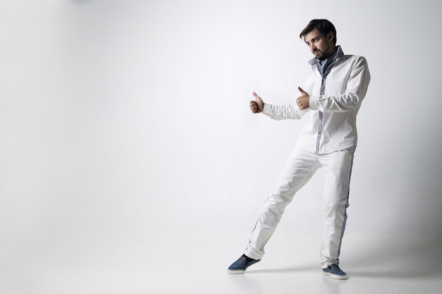 Retrato de un joven emocional vestido de blanco. Aislado sobre fondo blanco.