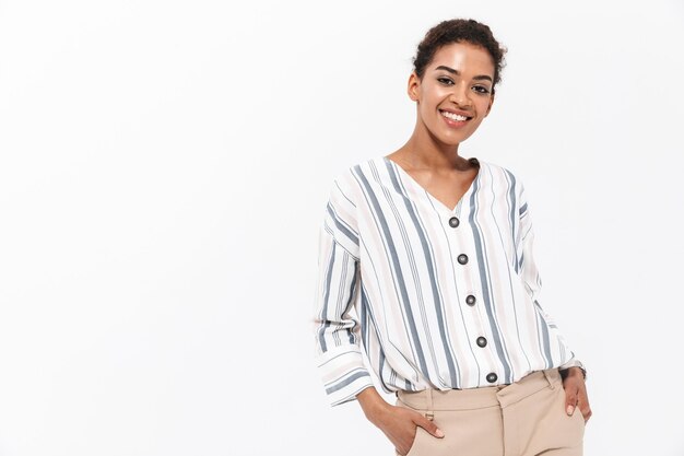 Retrato de una joven empresaria africana sonriente que se encuentran aisladas sobre la pared blanca, posando