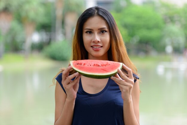 Retrato de joven empresaria asiática hermosa relajante en el parque al aire libre