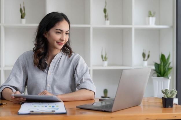Retrato de una joven empresaria asiática Mujer trabajando en una computadora portátil en su estación de trabajo Empleado independiente de personas de negocios Informe en línea de marketing de comercio electrónico Concepto de telemarketing