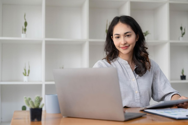 Retrato de una joven empresaria asiática Mujer trabajando en una computadora portátil en su estación de trabajo Empleado independiente de personas de negocios Informe en línea de marketing de comercio electrónico Concepto de telemarketing