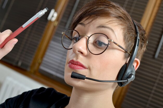 Retrato de una joven empresaria feliz con auriculares