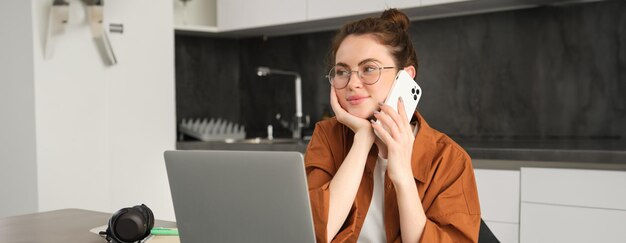 Retrato de una joven empresaria independiente que trabaja desde su casa, una freelancer que llama a una cliente.