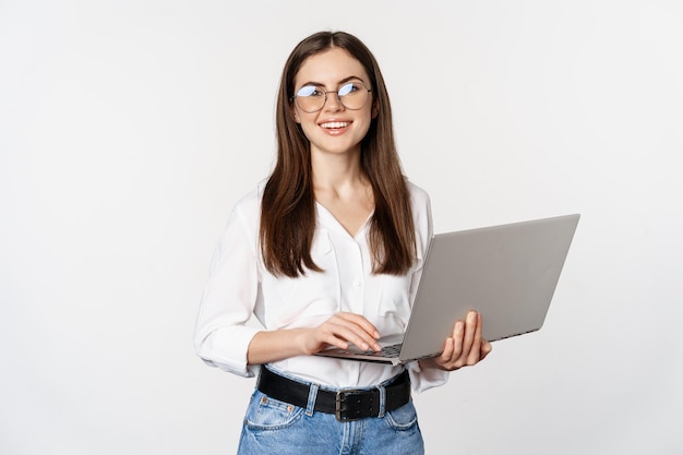 Retrato de una joven empresaria de oficina que responde a los clientes en una computadora portátil que trabaja con una computadora con feliz...