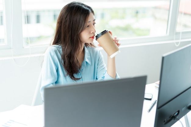 Retrato de joven empresaria sosteniendo la taza de café en la mano