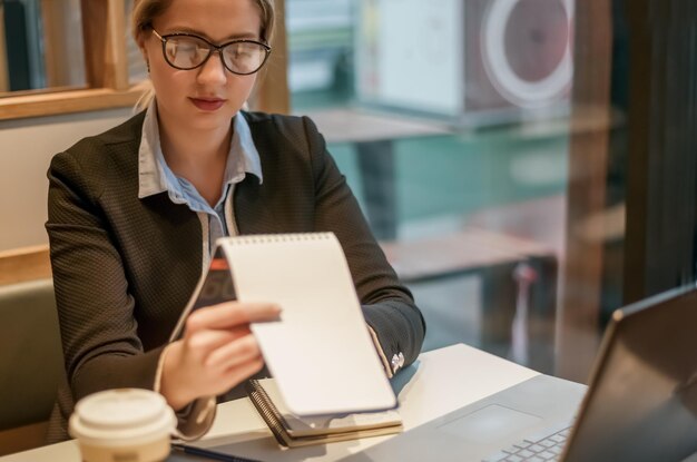 Foto retrato de una joven empresaria usando una computadora portátil en la oficina