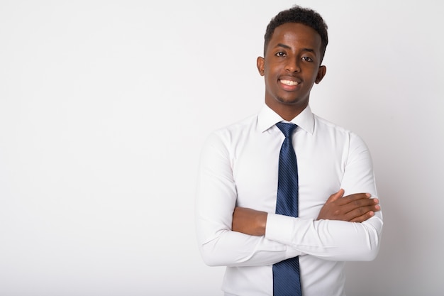 Retrato de joven empresario africano con cabello afro contra la pared blanca