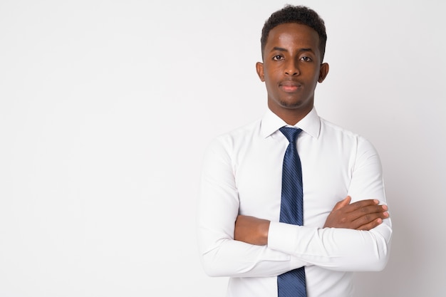 Retrato de joven empresario africano con cabello afro contra la pared blanca