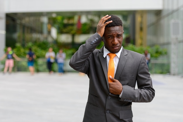 Retrato de joven empresario africano en la ciudad al aire libre