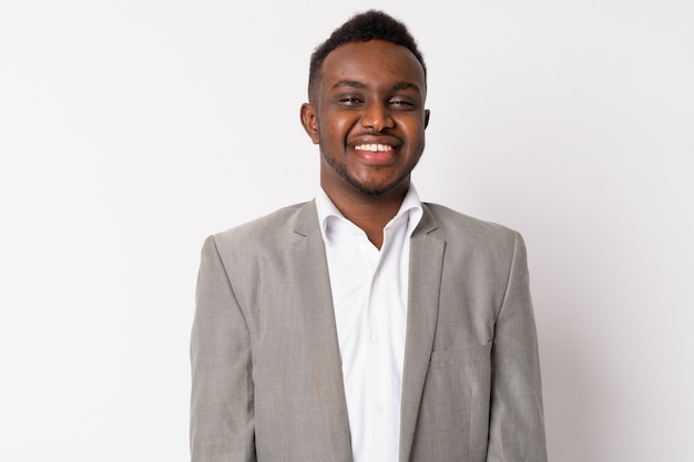 Retrato de joven empresario africano vistiendo traje contra la pared blanca