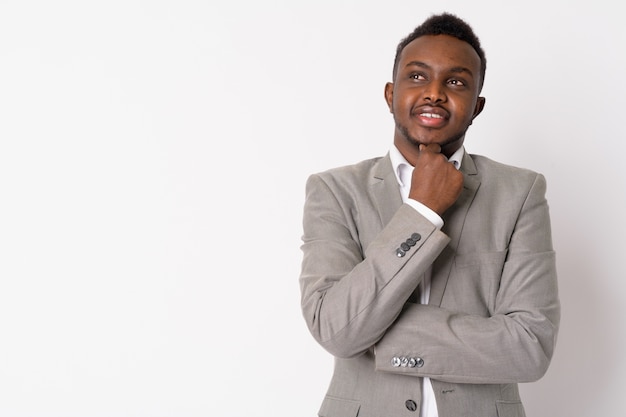 Retrato de joven empresario africano vistiendo traje contra la pared blanca