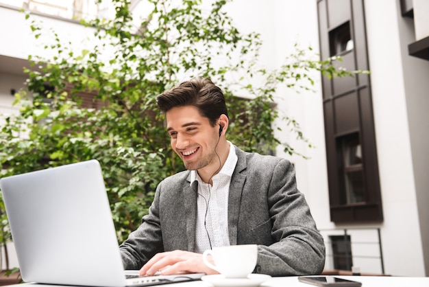 Retrato de un joven empresario alegre en auriculares