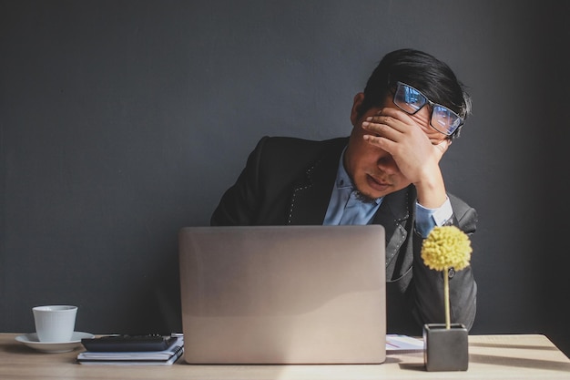 Retrato de un joven empresario asiático cansado y estresante en el trabajo