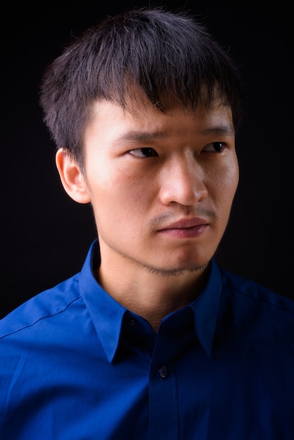 Foto retrato de joven empresario asiático pensando y mirando a otro lado