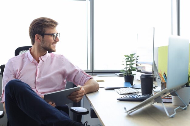 Retrato de un joven empresario casual feliz en la oficina.