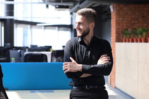 Retrato de un joven empresario casual feliz en la oficina.