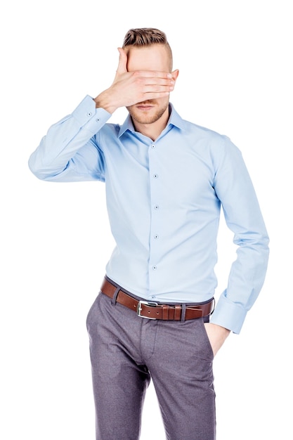 Retrato joven empresario cubriendo sus ojos con su mano emociones expresiones faciales sentimientos lenguaje corporal signos imagen sobre un fondo blanco de estudio