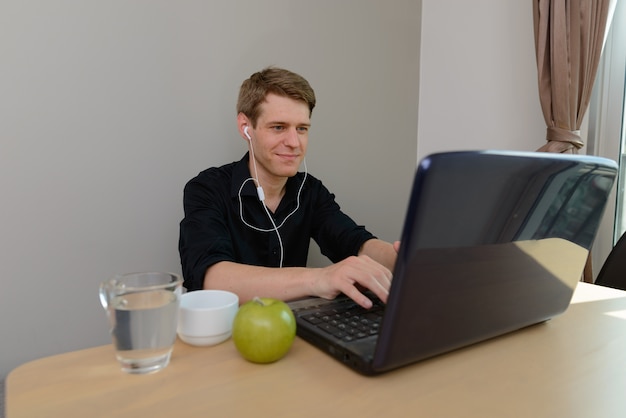 Retrato de joven empresario escandinavo guapo con cabello rubio en casa en el interior