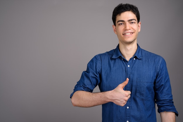 Retrato de joven empresario guapo contra gris