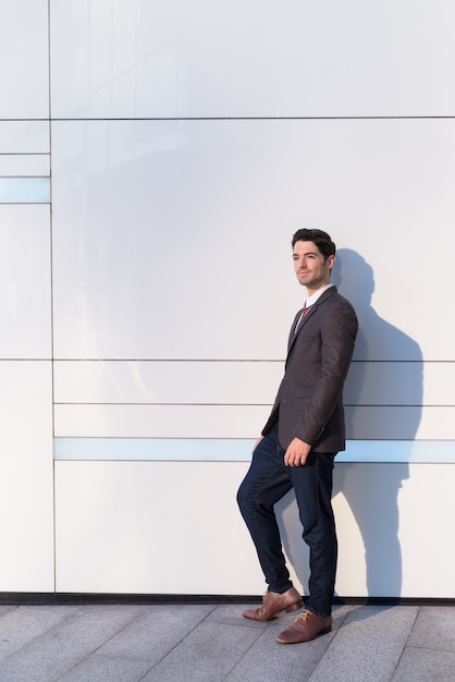 Retrato de joven empresario guapo vistiendo traje en la ciudad