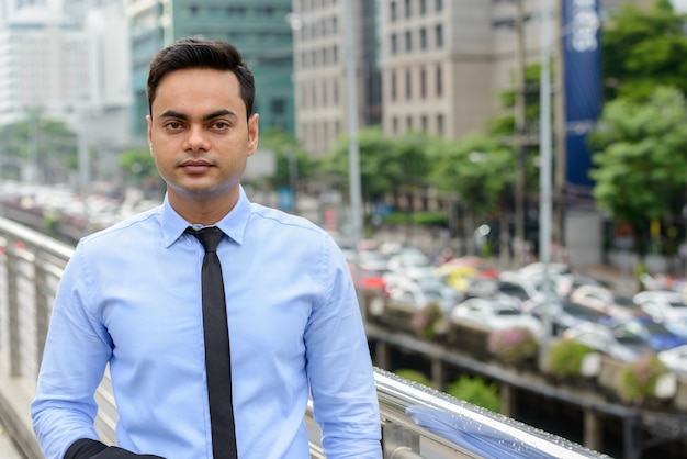 Retrato de joven empresario indio guapo en la ciudad