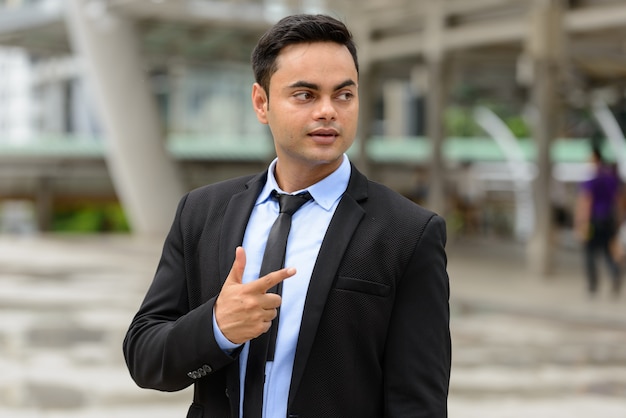 Retrato de joven empresario indio guapo en la ciudad