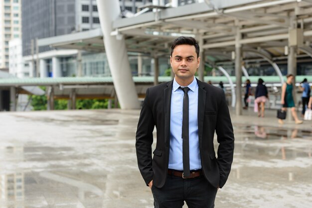 Retrato de joven empresario indio guapo en la ciudad