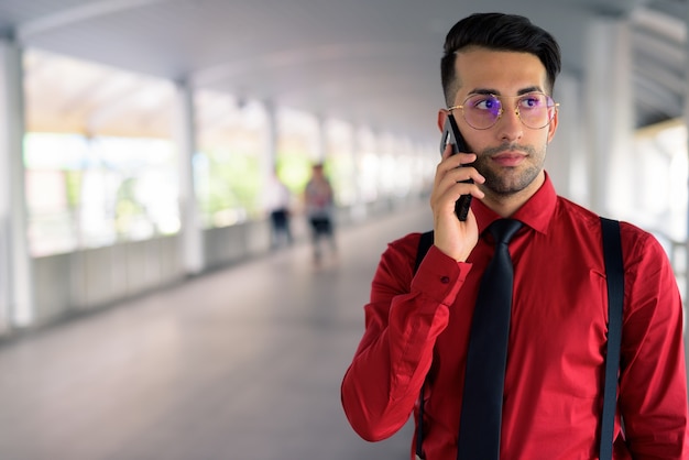 Retrato de joven empresario persa guapo explorando la ciudad de Bangkok, Tailandia