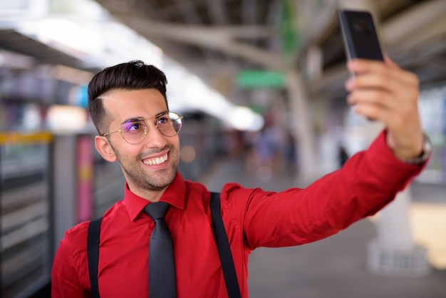 Retrato de joven empresario persa guapo explorando la ciudad de Bangkok, Tailandia