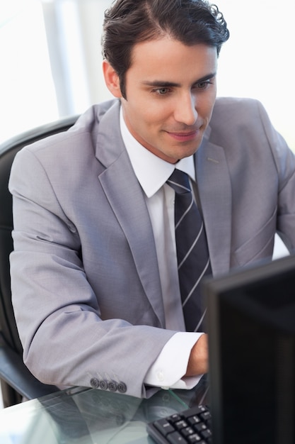 Retrato de un joven empresario que trabaja con una computadora