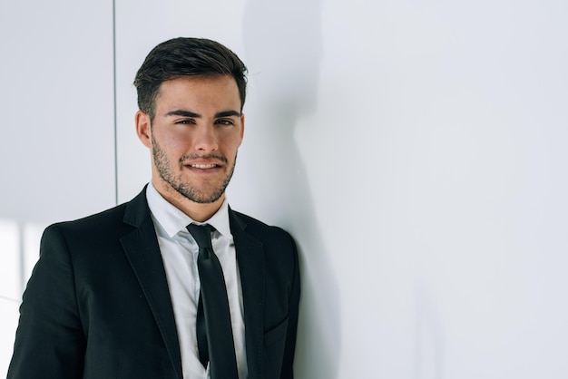 Retrato de joven empresario sonriendo en el aeropuerto con traje