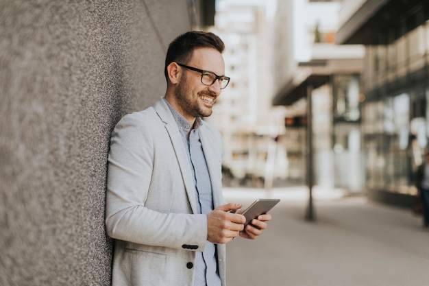 Retrato de un joven empresario con tableta digital al aire libre en entorno urbano