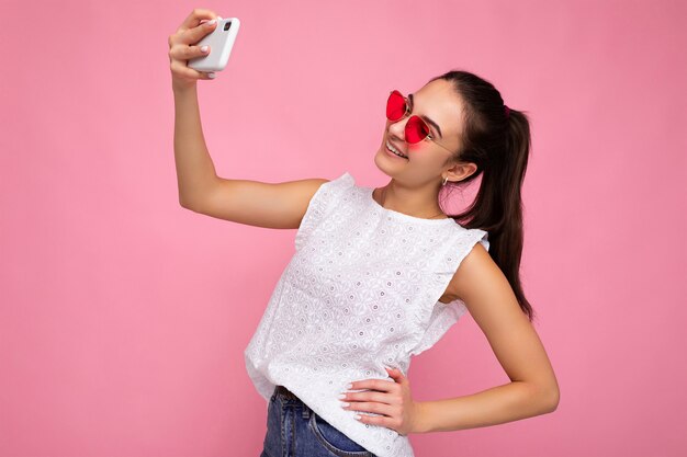 Retrato de joven encantadora hermosa mujer morena sonriente feliz con sinceras emociones vistiendo