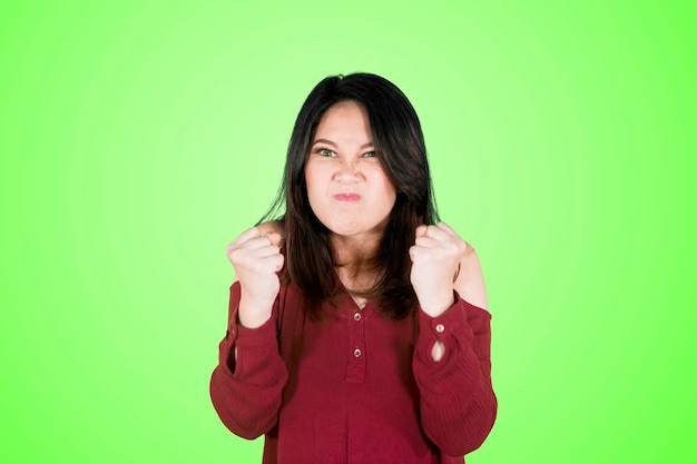 Foto retrato de una joven enojada contra un fondo verde