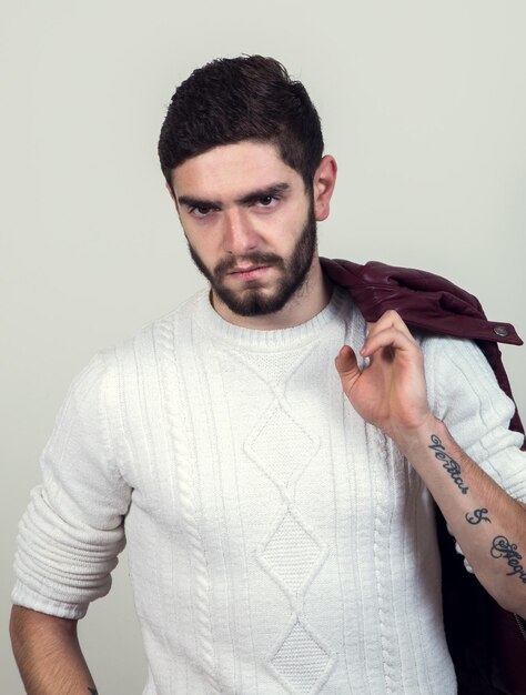 Foto retrato de un joven enojado de pie contra un fondo gris