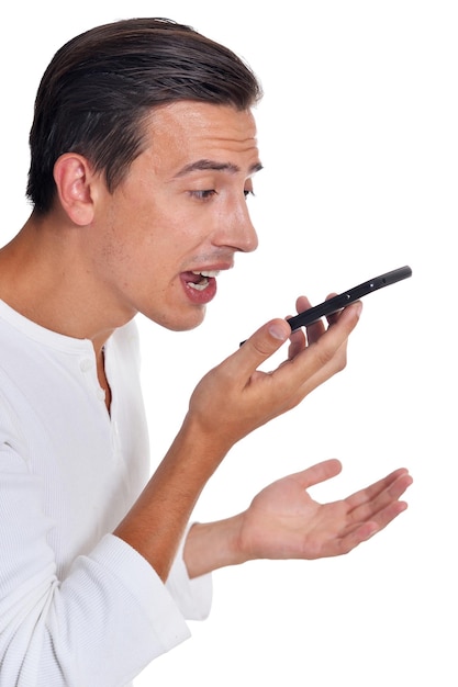 Retrato de un joven enojado vestido de blanco gritando en un smartphone posando en un fondo blanco