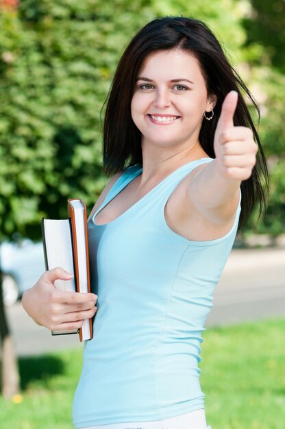 Retrato de una joven estudiante con libros en el campus