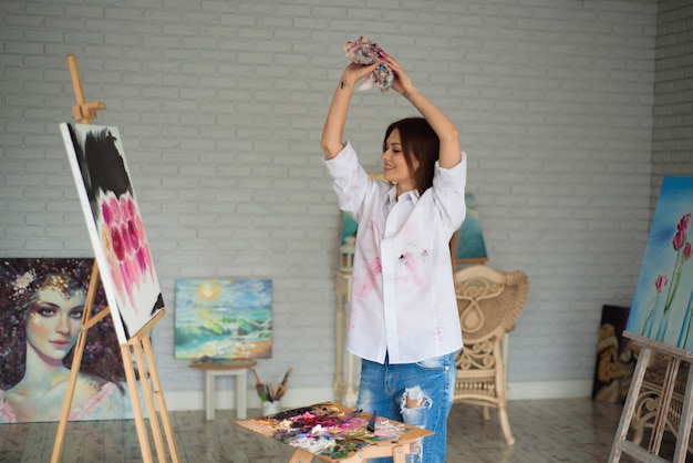 Retrato de un joven estudiante de pie con pintura en el estudio