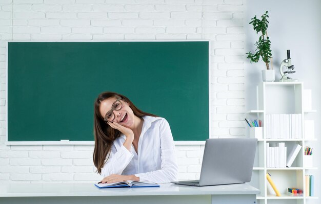 Retrato de un joven estudiante universitario sonriente que estudia con una computadora portátil en el aula de aprendizaje en línea