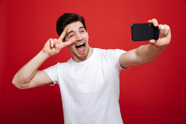 Retrato de un joven excitado con camiseta blanca