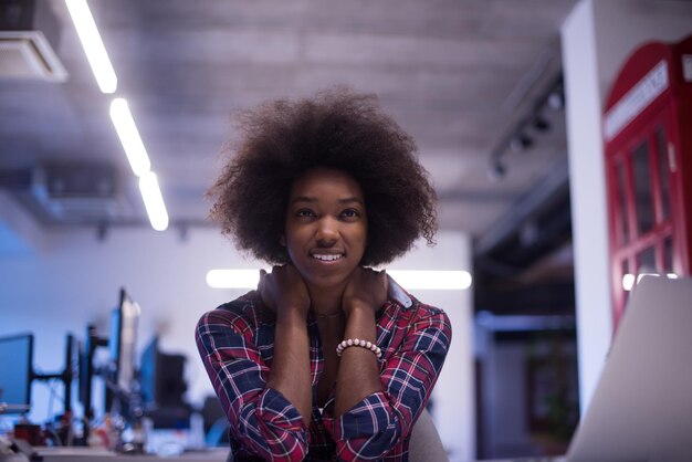 retrato de una joven y exitosa mujer afroamericana hermosa que disfruta pasar un tiempo alegre y de calidad mientras trabaja en una gran oficina moderna