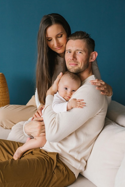 Retrato de una joven familia feliz con un niño en una casa acogedora