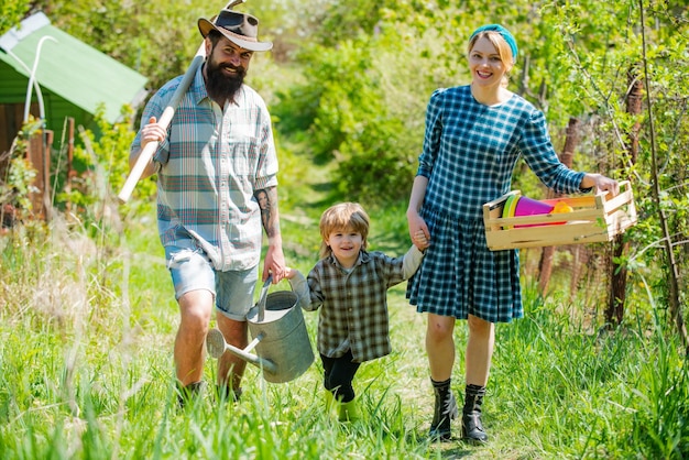 Retrato de una joven familia feliz en el patio durante la temporada de primavera Familia en la granja en el fondo del campo