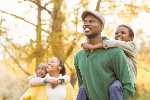 Retrato de una joven familia sonriente a cuestas