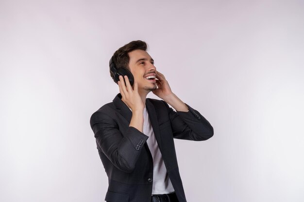 Retrato de un joven feliz con auriculares y disfrutando de la música sobre un fondo blanco